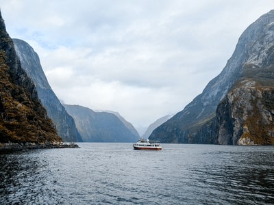 白色的船在海附近山上白天
